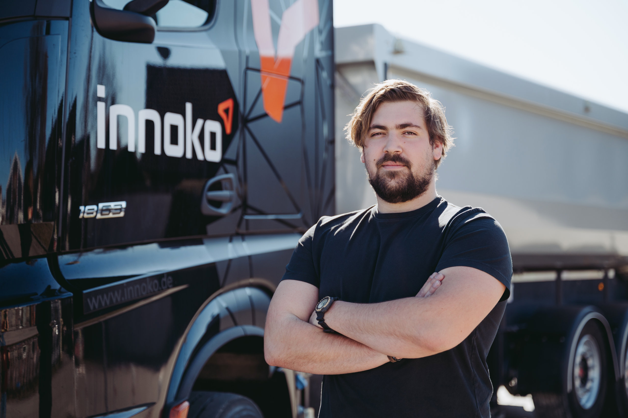 Mitarbeiter von Innoko Ein Mitarbeiter von Innoko steht vor einem LKW mit verschränkten Armen und Blick in die Kamera