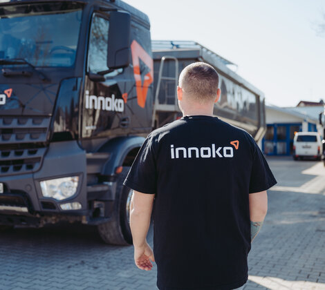 Mitarbeiter steht vor LKW. Rücken mit Innoko Logo zu sehen.