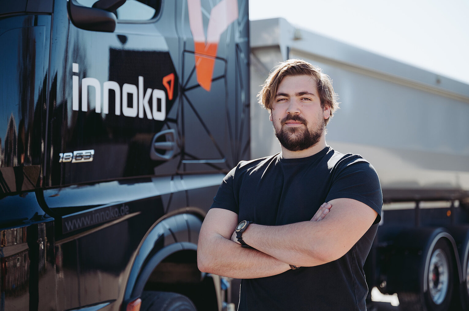 Mitarbeiter von Innoko Ein Mitarbeiter von Innoko steht vor einem LKW mit verschränkten Armen und Blick in die Kamera