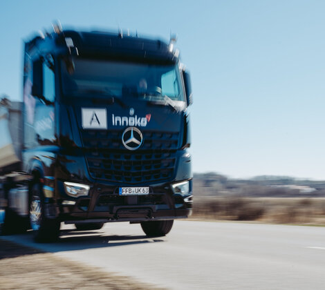 Schwarzer Innoko LKW fährt auf einer Landstraße